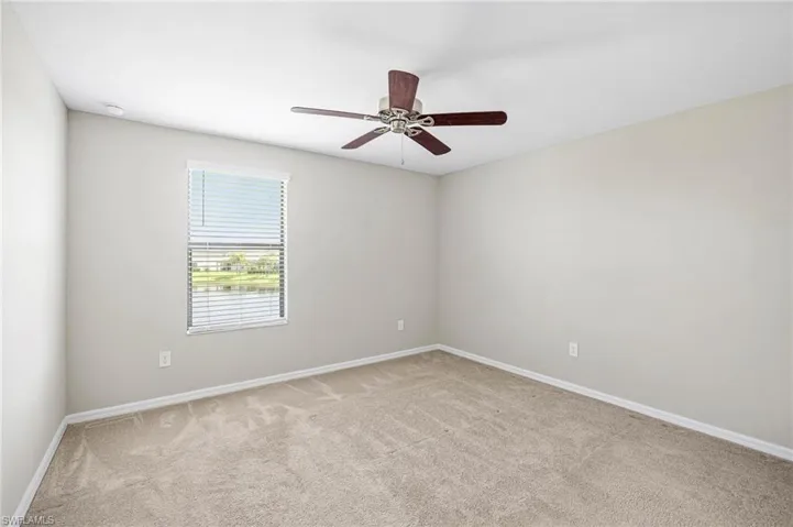 Carpeted spare room with ceiling fan