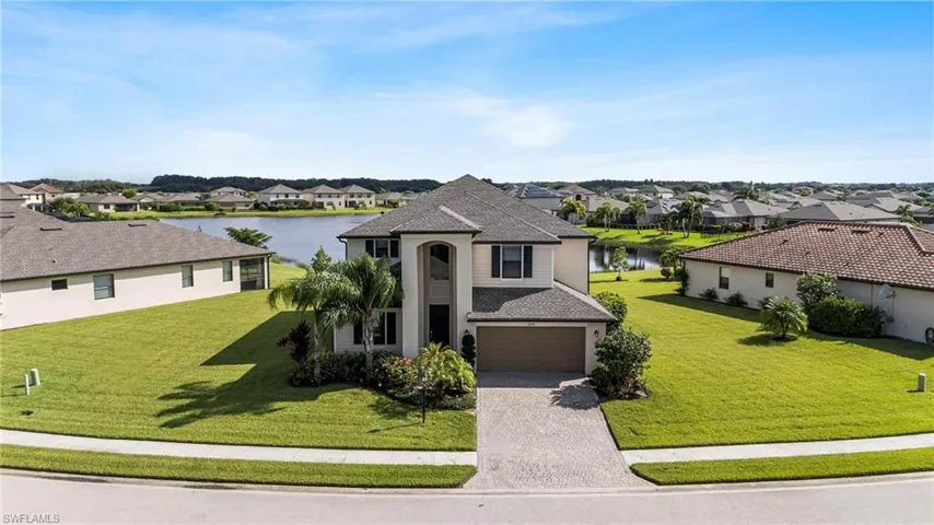 View of front of home featuring a garage, a water view, and a front lawn