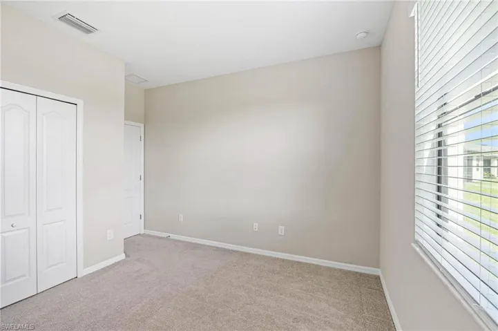 Unfurnished bedroom featuring light colored carpet and a closet