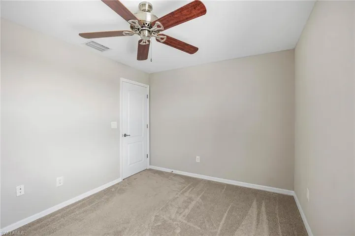 Carpeted spare room featuring ceiling fan