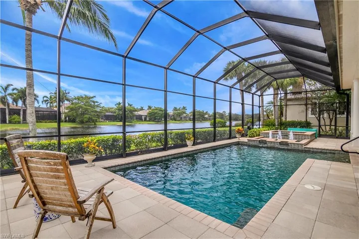 View of pool with a patio, an in ground hot tub, a water view, and a lanai