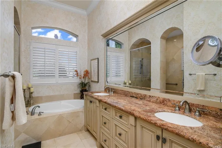 Bathroom with vanity, crown molding, shower with separate bathtub, and tile patterned floors