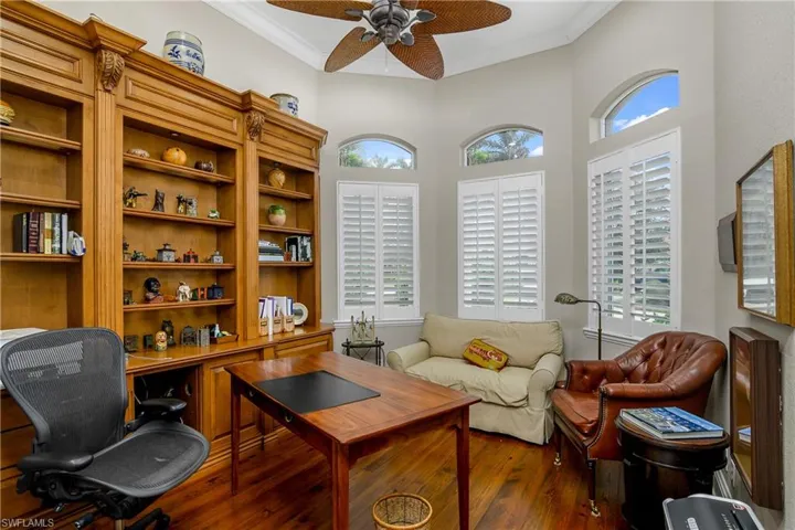 Office with crown molding, dark hardwood / wood-style flooring, and ceiling fan