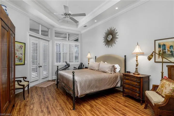 Bedroom featuring ornamental molding, access to exterior, hardwood / wood-style floors, and ceiling fan