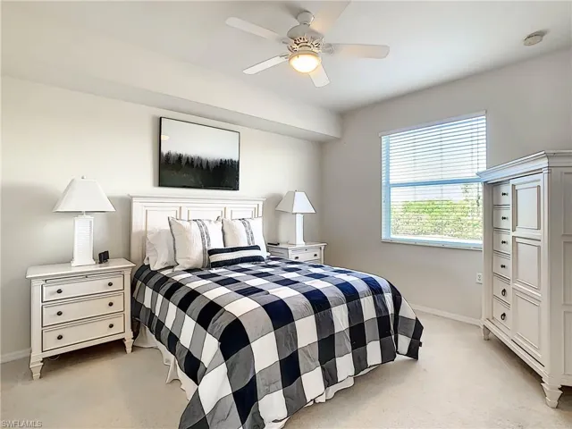 Bedroom with a ceiling fan and light colored carpet