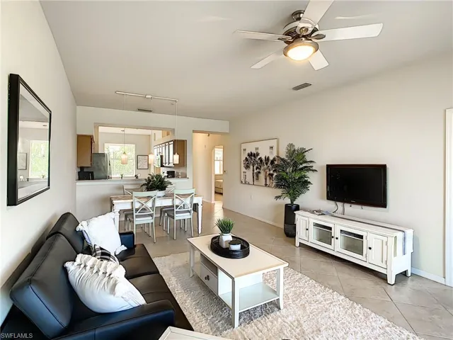 Living room with ceiling fan, light tile patterned flooring, and track lighting