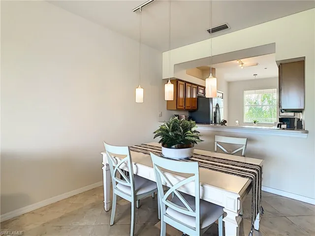 Dining space with rail lighting and light tile patterned floors