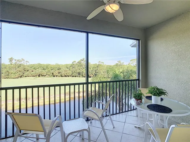 Sunroom with view of wooded area and golf course view