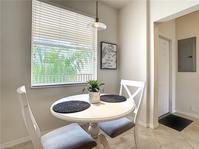 Dining space featuring electric panel and light tile patterned floors