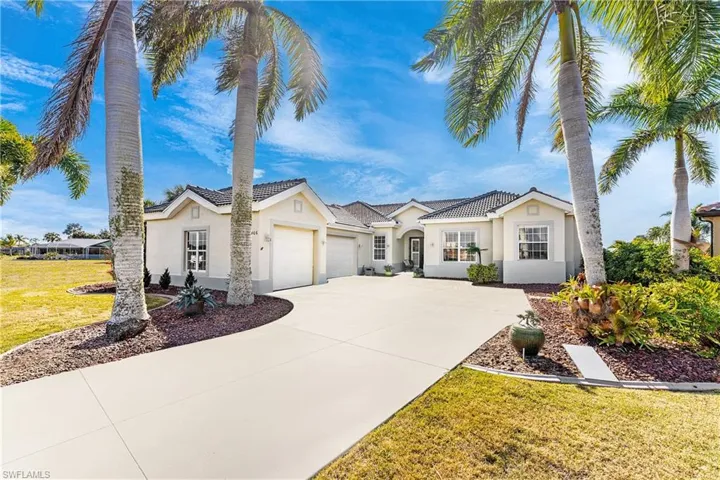 View of front of property with stucco siding, an attached garage, a front lawn, and concrete driveway