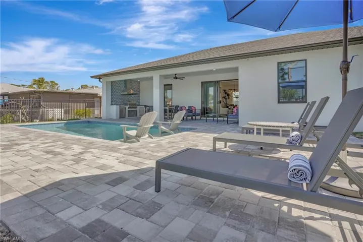View of swimming pool with ceiling fan and a patio area