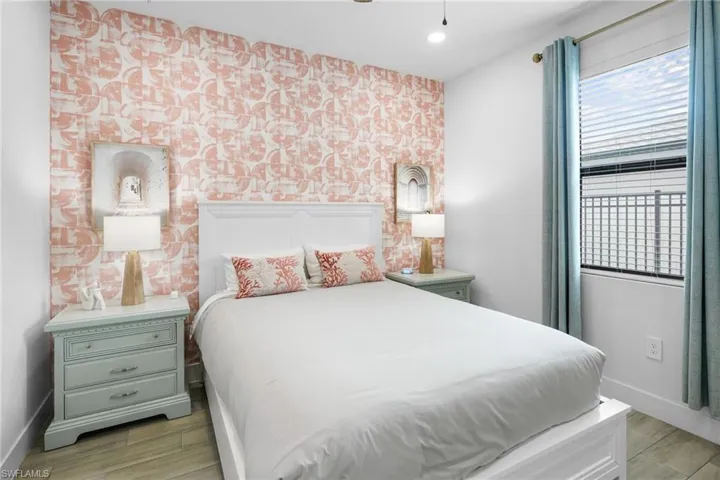 Bedroom with wood finish floors and an accent wall