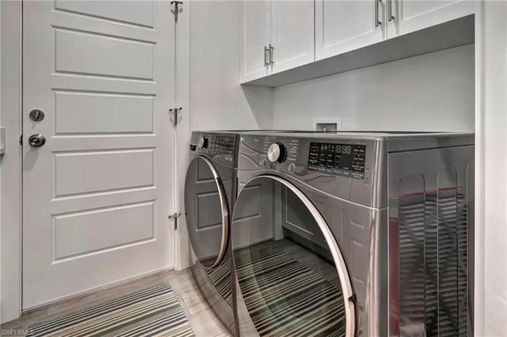 Laundry room with washer and clothes dryer and cabinet space