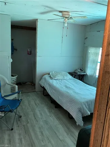 Bedroom with ceiling fan and laminate flooring