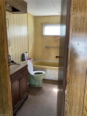 Full bathroom featuring . Shower/tub, panel walls, toilet, and vanity