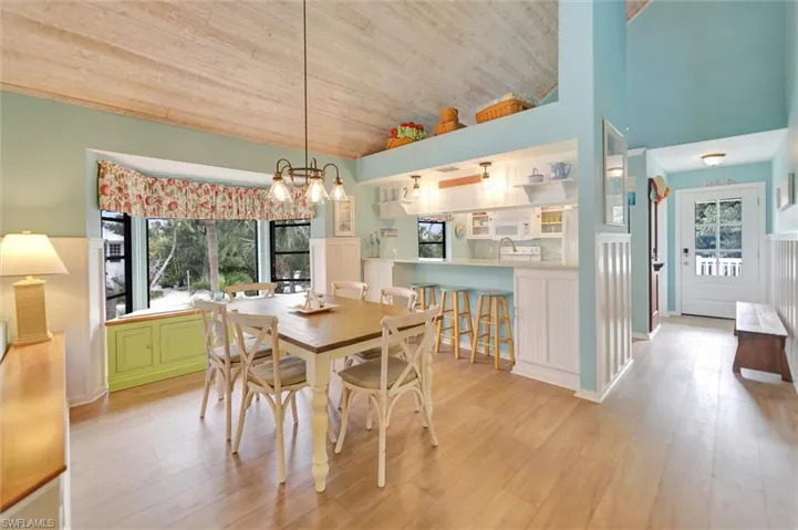 Dining room featuring a vaulted wood ceiling, light wood-style floors, and suspended lighting