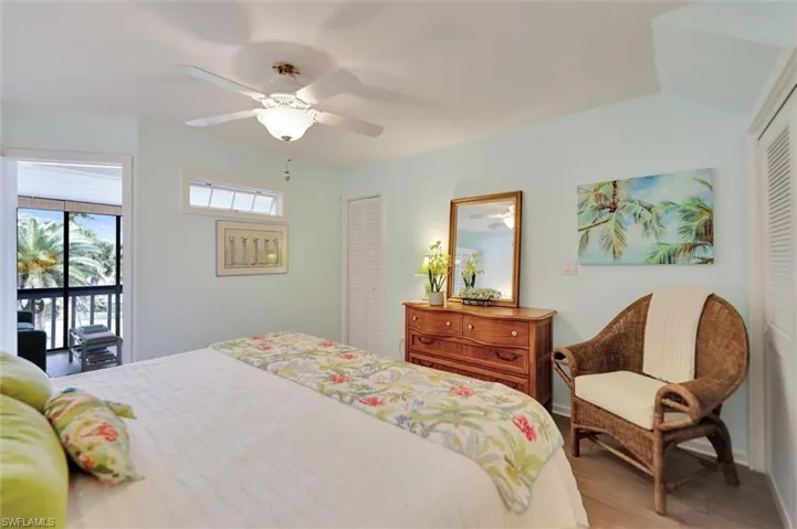 Bedroom with a closet, access to exterior, wood finished floors, and ceiling fan