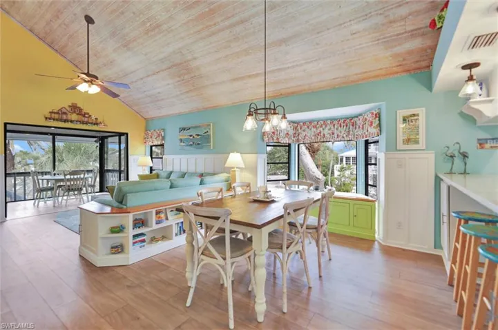 Dining room featuring wainscoting, a decorative wall, a vaulted wood ceiling, a chandelier, and light wood-style floors
