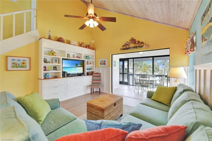 Living area featuring a ceiling fan, a vaulted wooden ceiling, and light wood-style floors