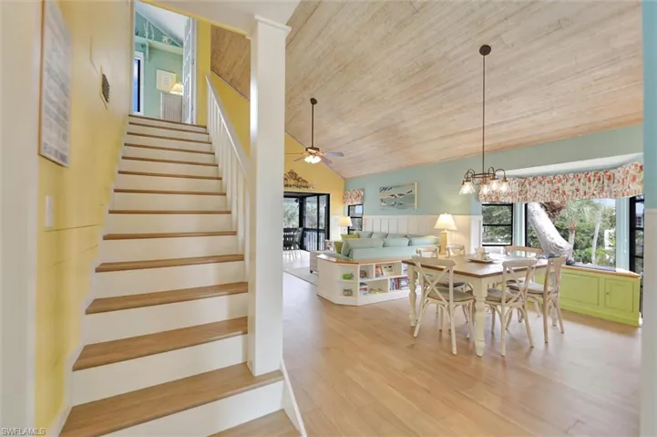 Dining area featuring a vaulted wooden ceiling, light wood-style flooring, healthy amount of natural light, a chandelier, and ceiling fan