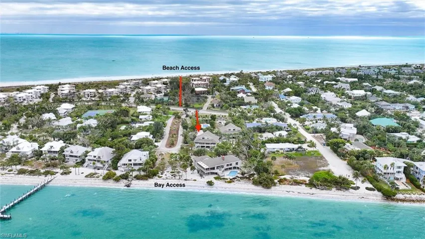 Aerial overview of property's location featuring expansive beach and nearby suburban area