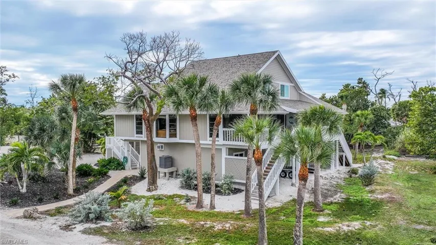 Beach home with a balcony and roof with shingles