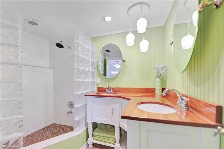 Full bathroom with a walk in shower, double vanity, and recessed lighting