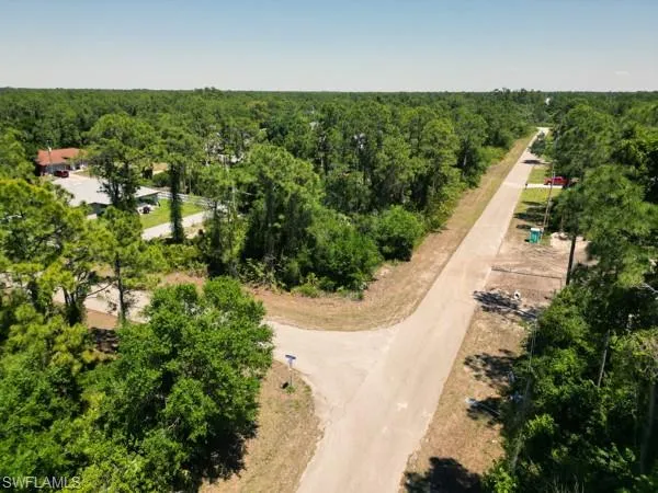 Birds eye view of property with a wooded view