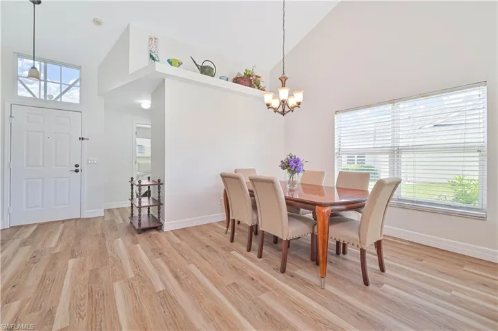 Living area featuring a ceiling fan, light wood finished floors, high vaulted ceiling, and healthy amount of natural light