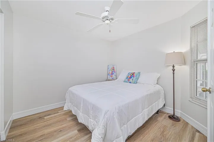 Bedroom with access to exterior, light wood-style flooring, and a ceiling fan