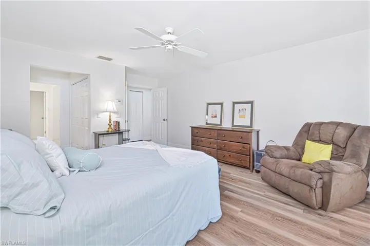 Ensuite bathroom featuring light wood-style floors, a tile shower, and ceiling fan