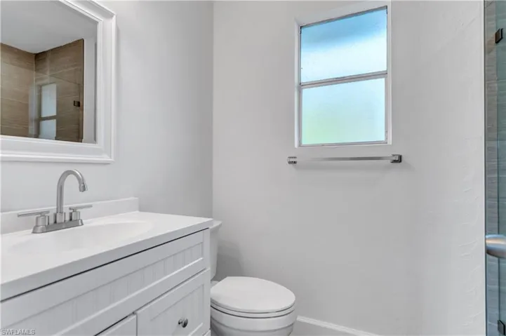Bathroom with an enclosed shower, toilet, and vanity
