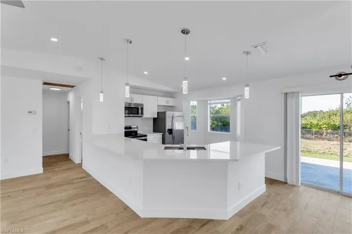 Kitchen with a sink, visible vents, appliances with stainless steel finishes, and light countertops