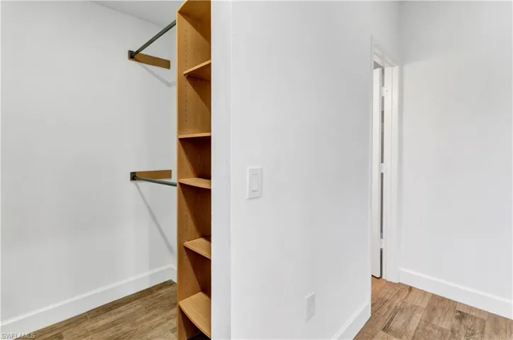 Walk in closet with wood finished floors