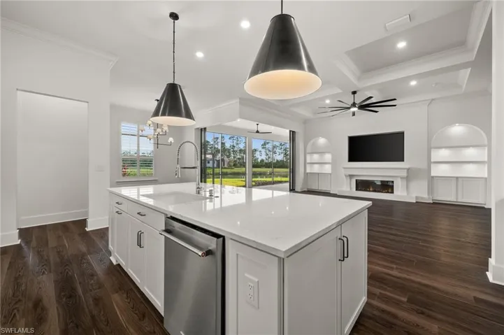 Kitchen with a sink, dishwasher, ornamental molding, ceiling fan, and coffered ceiling