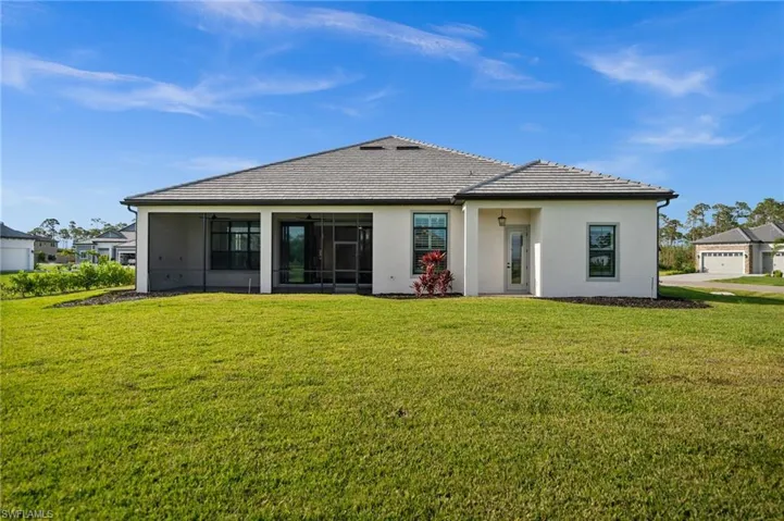 Back of property with a yard, a sunroom, and stucco siding
