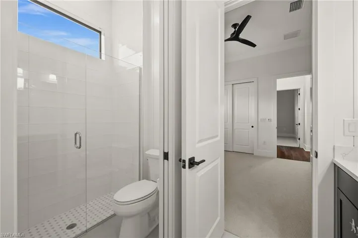 Full bath featuring crown molding, a shower stall, vanity, and toilet