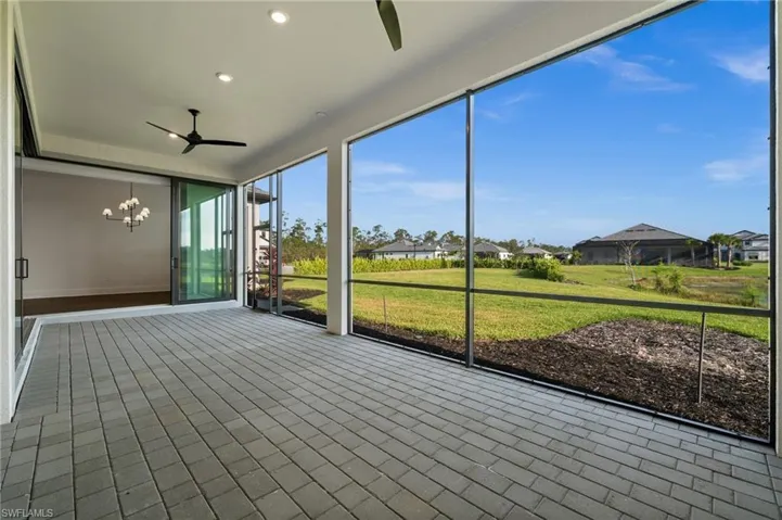 Unfurnished sunroom featuring ceiling fan and a chandelier