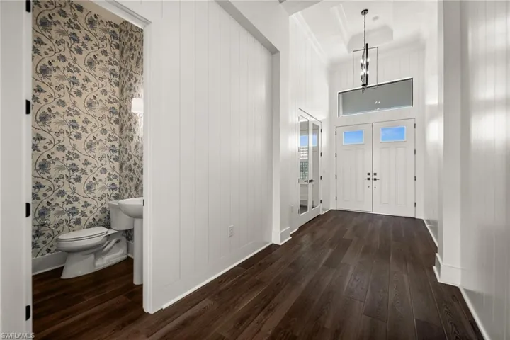 Entrance foyer featuring dark wood-style floors, baseboards, and ornamental molding