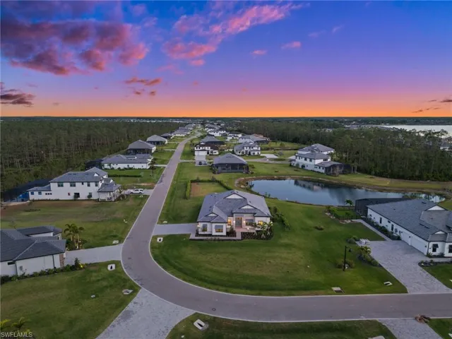 Aerial view at dusk of a water view, a residential view, and a forest view