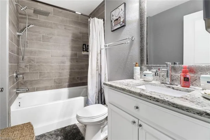 Guest Full bathroom featuring shower / bath combination with curtain, vanity, and toilet