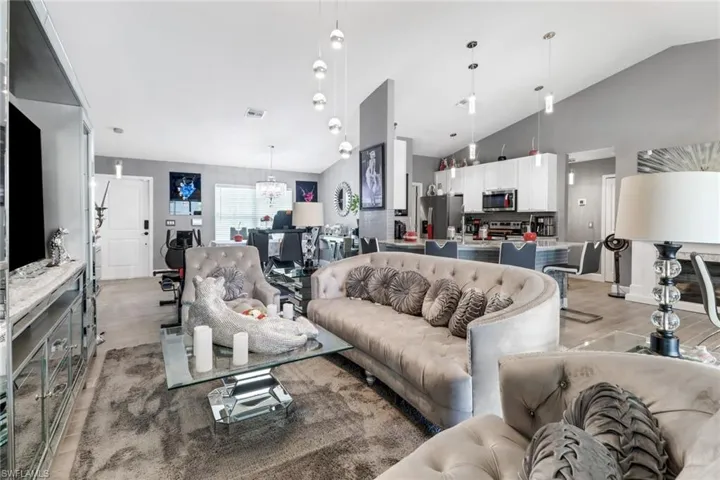 Living room featuring lofted ceiling, an inviting chandelier, and light hardwood / wood-style flooring