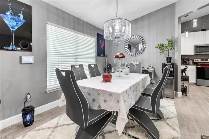 Dining space with light wood TILE flooring and a chandelier