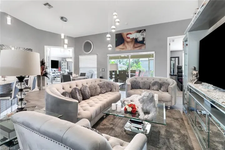 Living room with light wood Tile flooring and lofted ceiling