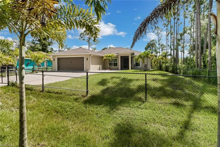 Ranch-style home featuring a garage and a front lawn