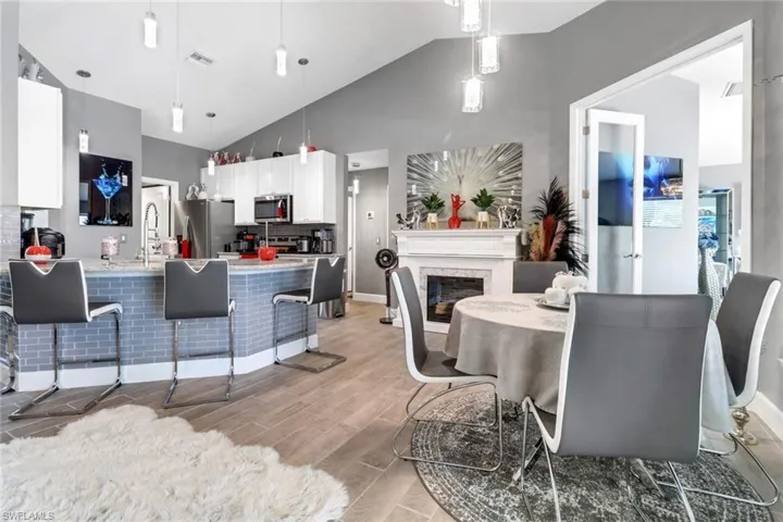Dining area featuring high vaulted ceiling, light wood-type flooring, and sink