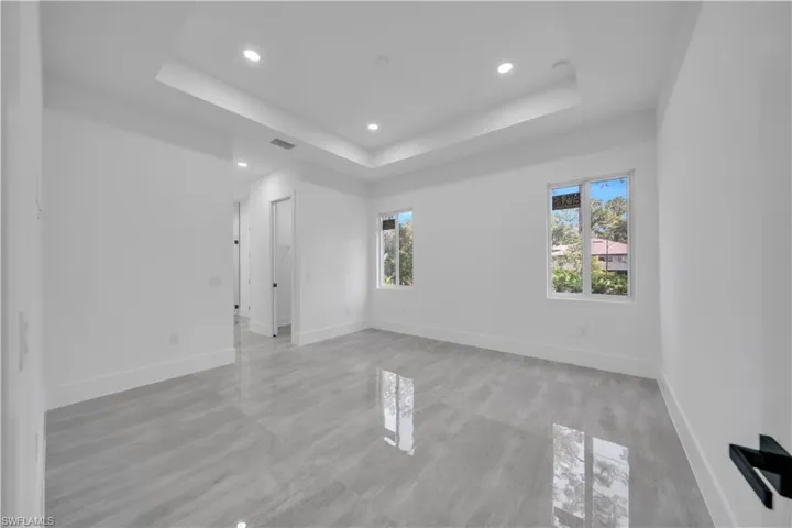 Empty room with a tray ceiling and recessed lighting