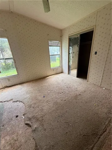 Unfurnished bedroom featuring carpet flooring, a textured ceiling, ceiling fan, a closet, and crown molding