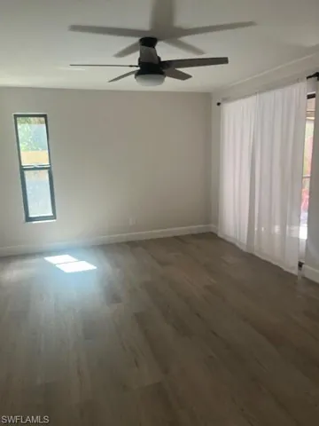 Spare room featuring wood finished floors, baseboards, and a ceiling fan