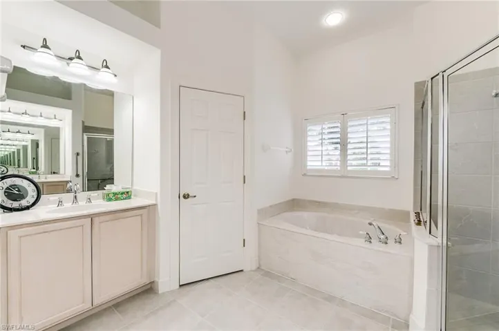 Primary bath with sink on the left and to the right of the soaking tub and shower is anotjher sink.